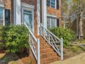 Inviting entryway showcases a brick staircase with white railings leading to a light blue front door at 4818 Glendarion Dr, Durham, NC 27713