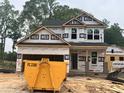 New home construction shows covered framing, black roof, and brick foundation at 49 Fetterbush Way, Clayton, NC 27520