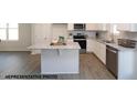 Modern kitchen with white cabinets, gray countertops, stainless steel appliances, and island for food preparation at 49 Fetterbush Way, Clayton, NC 27520