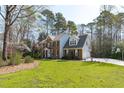 Gorgeous two-story brick home with an attached garage surrounded by trees at 5220 Linksland Dr, Holly Springs, NC 27540