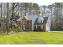 Beautiful two-story brick home with a well-maintained lawn and tree line at 5220 Linksland Dr, Holly Springs, NC 27540