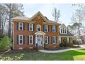Charming two-story brick home with blue shutters and front door at 5220 Linksland Dr, Holly Springs, NC 27540