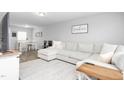 Bright living room featuring a large sectional couch, stylish rug, and contemporary decor with open view to the dining area at 5310 Gannet Ct, Snow Camp, NC 27349