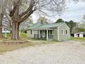 Side view of a cozy home with a green metal roof, charming porch, and gravel driveway at 540 S Cheatham St, Franklinton, NC 27525