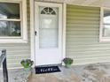 Charming front porch with potted plants and a 'hello' welcome mat by a bright white front door at 540 S Cheatham St, Franklinton, NC 27525