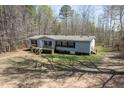 Aerial view of a single-level home with a front porch and a spacious yard surrounded by trees at 55 J B Rd, Louisburg, NC 27549