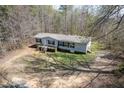 An aerial view of the single-level house with a front porch surrounded by a lush tree line and natural landscape at 55 J B Rd, Louisburg, NC 27549