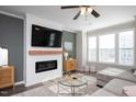 Bright living room with fireplace, mounted TV, ceiling fan, and lots of natural light at 5918 Giddings St, Raleigh, NC 27616