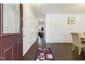 Bright foyer with dark wood floors, white walls, and an inviting view of the kitchen and dining area at 6021 Watsonia Dr, Zebulon, NC 27597
