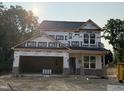 New construction home featuring a two-car garage and large windows, wrapped for weather protection during the building process at 61 Fetterbush Way, Clayton, NC 27520