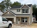 Charming two-story home featuring a mix of siding and brick accents with black shutters at 61 Fetterbush Way, Clayton, NC 27520