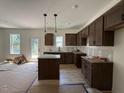 New kitchen with brown cabinets, granite countertops, and stainless steel sink at 61 Fetterbush Way, Clayton, NC 27520