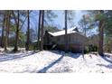 The exterior of the home is nestled among mature trees, with a light covering of snow at 6509A Fowler Rd, Zebulon, NC 27597