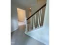 View of the carpeted staircase with white wood trim and dark wood handrail in a home with neutral colored walls at 7109 River Birch Dr, Raleigh, NC 27613