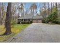 Exterior view showcasing a charming home nestled among trees with a long driveway at 7212 Rabbit Run, Wake Forest, NC 27587