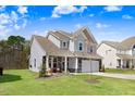 Charming two-story home with a well-manicured lawn and inviting front porch at 825 Golden Plum Ln, Zebulon, NC 27597