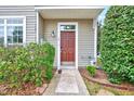 Front entrance features a solid door, manicured shrubs, and a welcoming pathway at 8641 Neuse Club Ln # 110, Raleigh, NC 27604