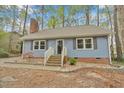 Charming blue home with a brick accent, featuring a welcoming front entrance and manicured landscaping at 1010 Flanders St, Garner, NC 27529