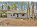 Lovely blue home with a cozy entrance and well-maintained landscaping surrounded by mature trees at 1010 Flanders St, Garner, NC 27529