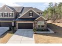Lovely townhome featuring a stone facade, a convenient two-car garage, and colorful front garden at 1012 Catch Fly Ln, Durham, NC 27713