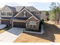 Attractive townhome with stone detailing, a two-car garage, and a neat front yard with flowerpots at 1012 Catch Fly Ln, Durham, NC 27713