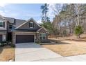 Beautiful townhome showcasing stone accents, a two-car garage, and a well-maintained lawn at 1012 Catch Fly Ln, Durham, NC 27713