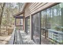 View of the deck with sliding glass doors leading to the interior space, surrounded by trees at 103 Morningside Dr, Carrboro, NC 27510