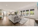 Bright and open living area with large windows, hardwood floors, and a view of the kitchen at 1121 White Oak Creek Dr, Apex, NC 27523