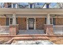 Inviting covered front porch with brick columns and black front door at 1133 Turner Farms Rd, Garner, NC 27529
