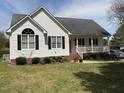 Home exterior showing the front yard, flower beds, and covered porch with white railings at 126 W Quail Ridge Rd, Oxford, NC 27565