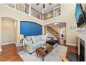 Comfortable living room with a statement blue accent wall and an open layout to the staircase and foyer at 1524 Catch Fly Ln, Durham, NC 27713