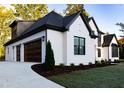 Elegant home exterior with dark trim, a two-car garage, and a well-maintained lawn at 186 Evington Dr, Pittsboro, NC 27312