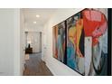 Bright hallway featuring modern artwork and hardwood floors, leading to other rooms at 201 Olive Branch St, Sanford, NC 27332