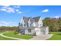 Picturesque white two-story house with a front-facing garage, and a bright blue sky at 216 Meadow Walk Dr, Fuquay Varina, NC 27526