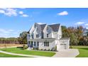 Lovely two-story white home with an attached garage, mature trees, and landscaping at 216 Meadow Walk Dr, Fuquay Varina, NC 27526