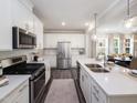 Bright kitchen featuring stainless steel appliances, white cabinets, a kitchen island, and sleek countertops at 233 Shingle Oak Rd, Wake Forest, NC 27587