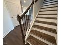Elegant staircase with wood treads, wrought iron spindles, and freshly painted white risers at 237 Shingle Oak Rd, Wake Forest, NC 27587