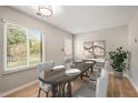 Dining area featuring a wooden table set for four, bright light, and a large window overlooking the exterior at 2416 Boothbay Ct, Raleigh, NC 27613
