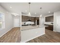 Modern kitchen features granite countertops, stainless steel appliances, an island, and ample storage space at 248 Shingle Oak Rd, Wake Forest, NC 27587