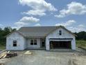 New construction home featuring an open garage, gray roof, and bright natural light at 249 Spilona Way # 64, Four Oaks, NC 27524