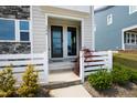 Inviting front door entrance with a decorative tree and neatly trimmed shrubs and a white fence at 249 Wendover Pkwy, Pittsboro, NC 27312