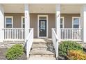 Inviting front porch features stone steps, white railings and columns, and a decorative wreath at 274 Ashpole Trl, Clayton, NC 27520