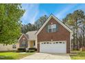 Lovely brick and siding home with manicured bushes, a paved driveway, and a two-car garage at 3213 Kirby St, Durham, NC 27713