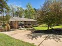 A charming brick home showcasing a spacious driveway, inviting front porch, and lush green lawn at 416 Avery St, Garner, NC 27529