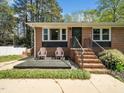 Inviting front porch features seating and a charming brick facade, creating a welcoming entrance at 416 Avery St, Garner, NC 27529
