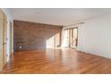 Sunlit living room with hardwood floors and exposed brick accent wall at 4229 American Dr # F, Durham, NC 27705