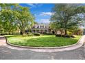 Traditional home with lush front lawn, manicured bushes, and a long porch with a red front door at 4303 Thetford Rd, Durham, NC 27707