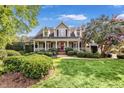 Inviting front exterior showcases lush lawn and landscaping, columns, and a red front door at 4303 Thetford Rd, Durham, NC 27707