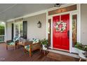 A covered front porch features outdoor seating near a red front door with floral wreath at 4303 Thetford Rd, Durham, NC 27707