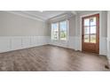 Welcoming entryway featuring hardwood floors, wainscoting, and a stylish wooden door at 508 Moore Hill Way, Holly Springs, NC 27540